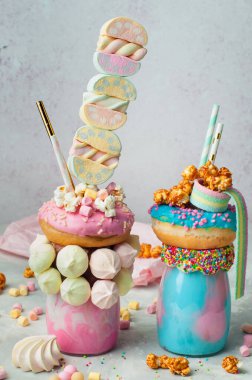 Mutlu yıllar parti geçmişi: Gri arka planda iki ucube üzerine donut, marşmelov, krema, patlamış mısır ve reçel; seçici odak noktası