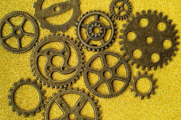 Top closeup view of gear wheels collection on glittering background with blank space for text. Top view, flat lay.