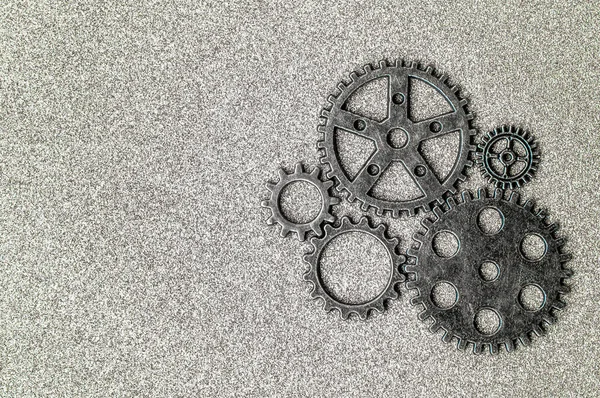 Top closeup view of gear wheels collection on glittering background with blank space for text. Top view, flat lay.