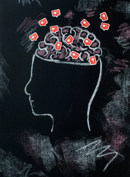Social networks concept. Profile of head with open brains full of likes symboles on black chalk board. Top view, flat lay.