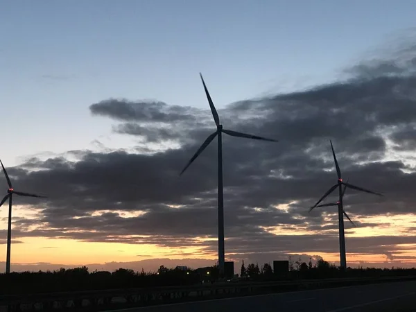 Wind farm and wind turbines with sunset and colorful sky and clouds