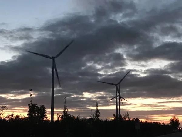 Wind farm and wind turbines with sunset and colorful sky and clouds