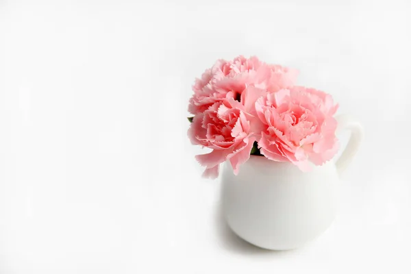 bouquet of pink carnations in a vase side view on a white background holiday concept