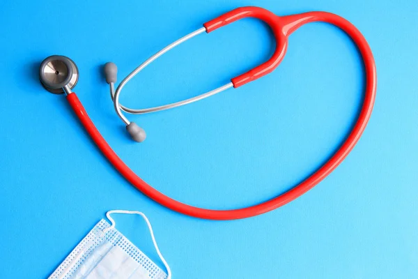 stethoscope and medical mask on a blue background concept of medicine, health, illness.