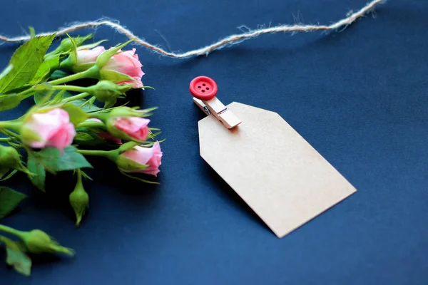 flowers, clothespins, paper for writing on a dark background concept of congratulations on the holiday