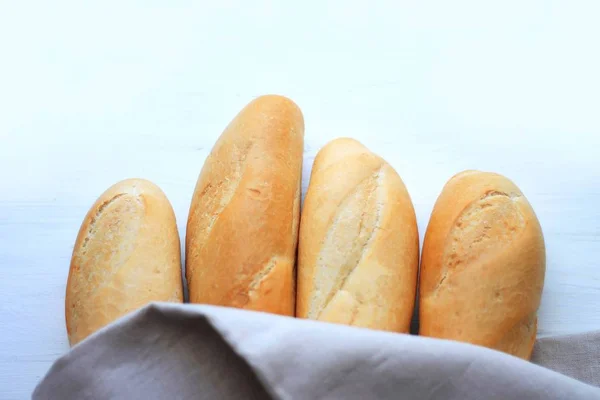french baguettes, loaves on a light wooden background