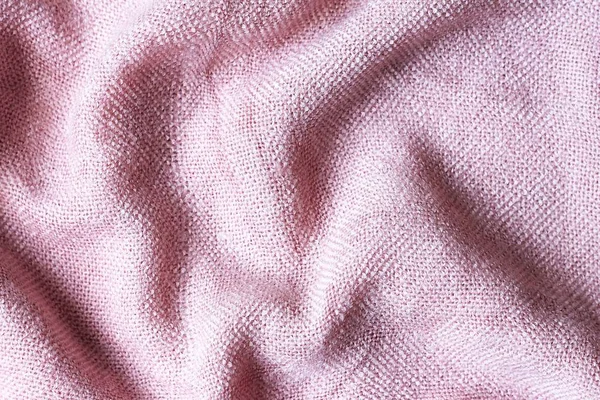 Texture of knitted pink fabric. Pink background. Light pink thick winter fabric