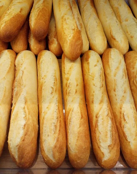 A few fresh baked baguettes. Bread in the supermarket, vertical photo.