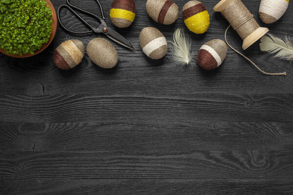 Easter background - eggs and decorations on a wooden black background