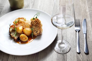 Patates ve kavrulmuş karnabahar ile kızarmış tavuk göğsü.