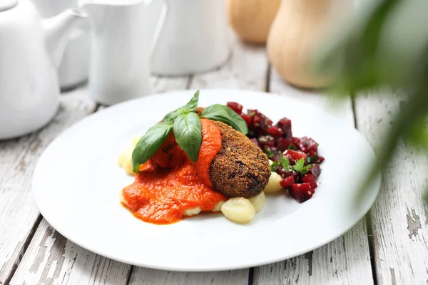 Chuletas de verduras servidas con salsa de tomate sobre albóndigas sobre ñoquis, ensalada de remolacha asada . — Foto de Stock