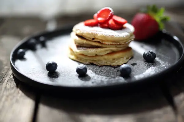 Panquecas com morangos, mirtilos e açúcar em pó . — Fotografia de Stock