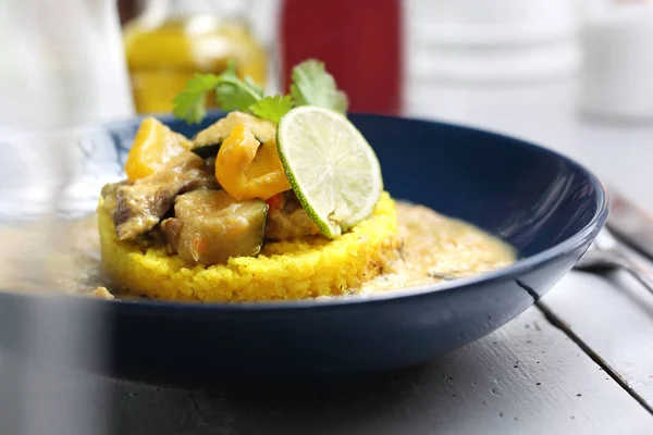 Yellow curry with eggplant, zucchini and celery served with yellow rice.