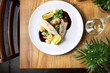 Tavuk Roulades Gorgonzola ile doldurulmuş, tereyağı, köfte, yeşil bezelye ve şarap sosu kızarmış pırasa ile servis.