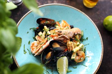 Deniz ürünleri ile Tagliatelle, karides, midye, langoustines, kalamar, beyaz şarap ilavesi ile