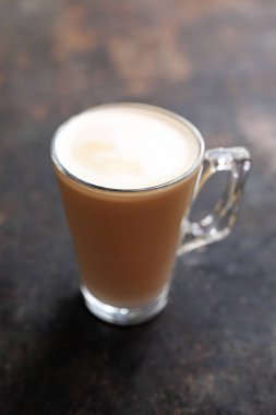 Süt köpük şeffaf cam bardak ile düz beyaz kahve.