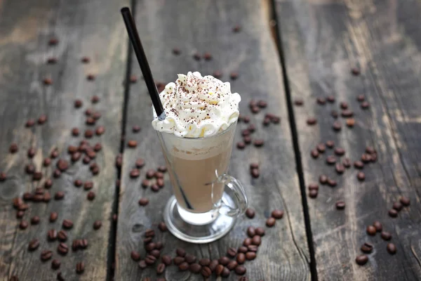Iced coffee, glass of coffee with milk, whipped cream and ice on a wooden background. — Stock Photo, Image