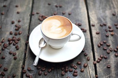 Sütlü kahve, ahşap arka planda süt köpüğü olan bir fincan kahve.