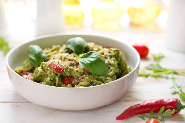 Ispanak ve domatesli makarna. Beyaz ahşap masa üzerinde bir tabak