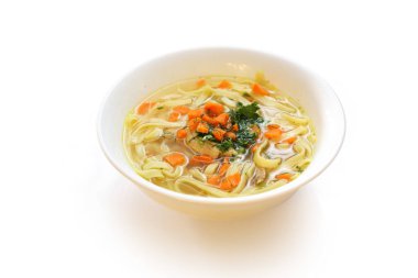 Erişteli ve havuçlu tavuk suyu. Beyaz arka planda bir tabak çorba