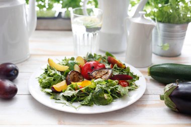 Roket salatasında ızgara sebze salatası, erik, şeftali ve sirke sosu..