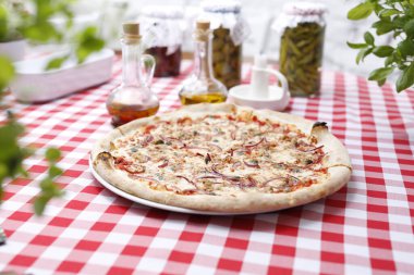 Ton balıklı pizza, soğan, kapari ve mozzarella peyniri. İtalyan mutfağı. Geleneksel İtalyan pizza. Yemek servisi için öneri. Gıda arkaplanı.