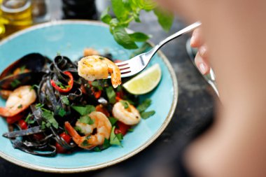 Deniz mahsullü makarna. Karides, midye ve ahtapotlu kara makarna. İştah açıcı yemek. Yemeği servis etmeyi öneriyorum. Mutfak fotoğrafçılığı.