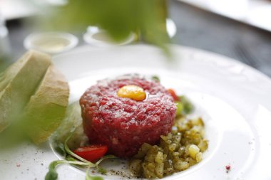 Biftek, turşu ve sarısı ile servis edilen biftek. İştah açıcı aperatif. Yemeği servis etmeyi öneriyorum. Mutfak fotoğrafçılığı.