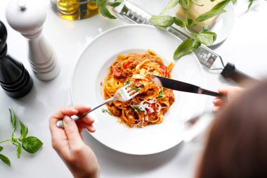 Bolonez soslu Tagliatelle, domates soslu makarna ve peynir. Geleneksel İtalyan mutfağı spagetti bolonez. Beyaz tabakta servis edilen iştah açıcı bir yemek. Mutfak fotoğrafçılığı.