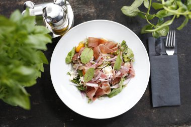 Parma jambonlu salata, domates, sarı pancar kökü ve salata sosu. Beyaz tabakta servis edilen aperatif tabağı. Mutfak fotoğrafçılığı.