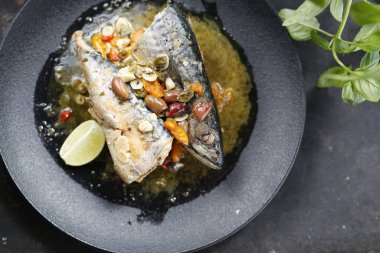 Kızarmış uskumru. Balık, sarımsak, zeytin ve limonla servis ediliyor. İştah açıcı tabakta servis ediliyor. Mutfak fotoğrafçılığı, yemek fotoğrafçılığı..