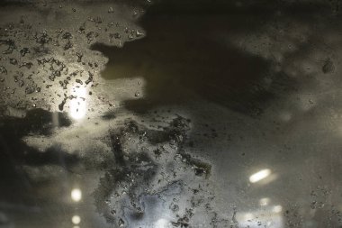 Blizzard akşam şehre karşı buzlu cam pencere sokak