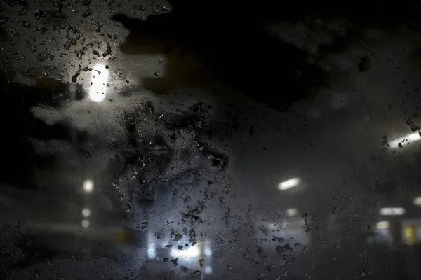 Ventisca en la calle de la ciudad por la noche contra la ventana helada —  Fotos de Stock