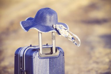 Seyahat aksesuarlarıyla birlikte dünya haritası yardımıyla turizm planlaması. Arka plan günbatımlı bavul ve şapka. Tatilde alınmaya hazır şeylerin seyahat konsepti..