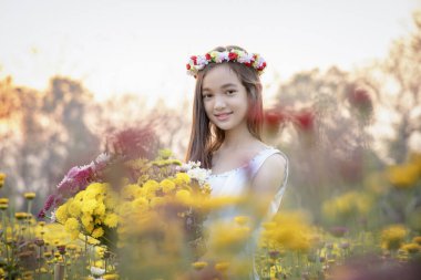 Renkli çiçeklerin yanında duran eski moda elbiseli ve şapkalı güzel bir kız. Arka planda poz veren güzel, romantik, genç bir kadın. İlham kaynağı..