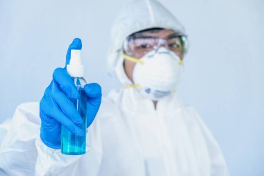 Doktorlar koronavirüs hastalığına karşı korunmak için yüz kalkanı / PPE takarlar. Doktor, koronavirüsü temizlemek için alkol kullanmamızı öneriyor..