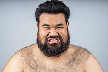 Tüylü sakallı şişman bir adam. Obez insanlar. Göbek yağının tehlikeleri. Koca göbekli şişman bir adam, diyabet riski olan erkekler. Şeker hastası insanlara obez ol..