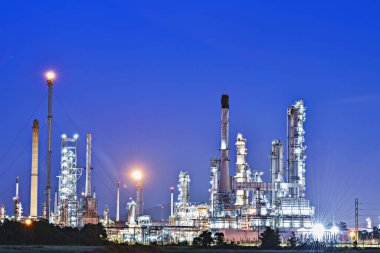 Petrol ve gaz endüstrisi depolama tankı ve boru hattı çeliği, alacakaranlıkta gökyüzü ve gece arkaplanı olan petrol rafinerisi. Gün batımında rafineri, petrol rafinerisi ve Petrokimya fabrikası..