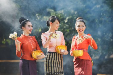 Songkran festivalinde su sıçratan Taylandlı kızlar, yetişkinlerin su kutsama töreni, Songkran festivalinde Buda heykeli su töreni, Tayland geleneksel.