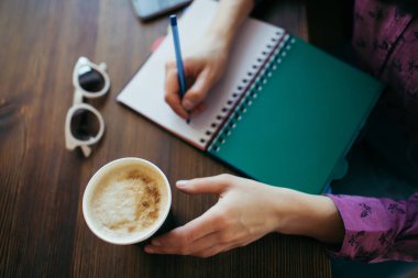 Hem kahve hem de kalem tutan kadınlılar elleriyle genel bakış.