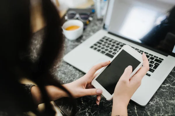 Evde Smartphone ile çalışan kadın.