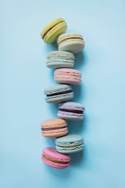 Pastel macaron o macarrón sobre fondo azul pastel desde arriba. Vista superior . —  Fotos de Stock