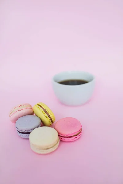Makronen und eine Tasse Kaffee auf rosa Hintergrund. — Stockfoto