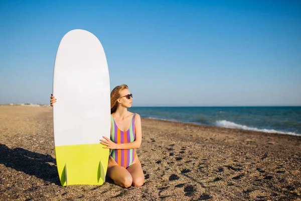 Young fit surfer girl on the beach with a surf board. — Stock Photo, Image