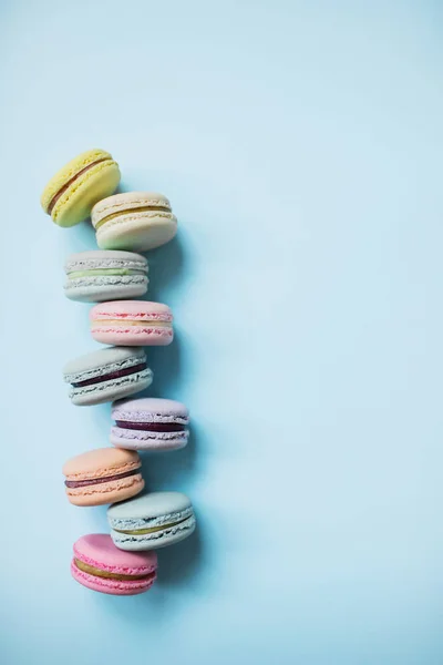 Makaron- oder Makronenkekse auf pastellblauem Hintergrund von oben. Ansicht von oben. — Stockfoto