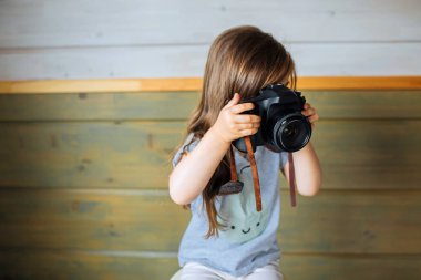 Fotoğraf makinesi ile küçük kız çocuk anlık görüntü yapıyor veya fotoğraf çekmek.