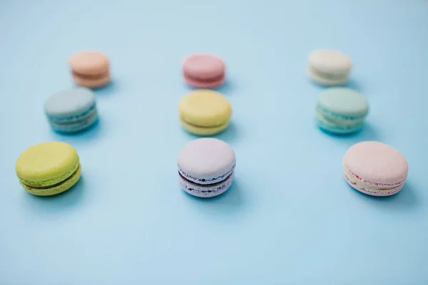 Primer plano de las galletas de macarrones o macarones franceses sobre fondo azul . —  Fotos de Stock