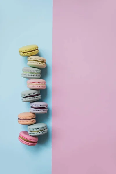 Makaron- oder Makronenkekse auf pastellblauem und rosa Hintergrund von oben. — Stockfoto