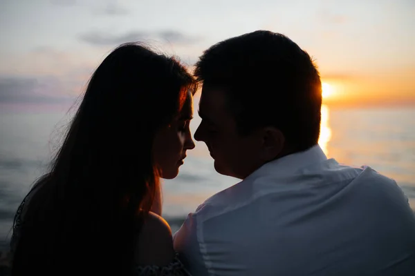 Fechar-se de jovem casal amoroso na praia ao pôr do sol . — Fotografia de Stock