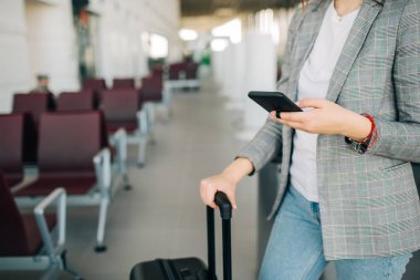 Akıllı telefon ve bagaj ile havaalanında Kız